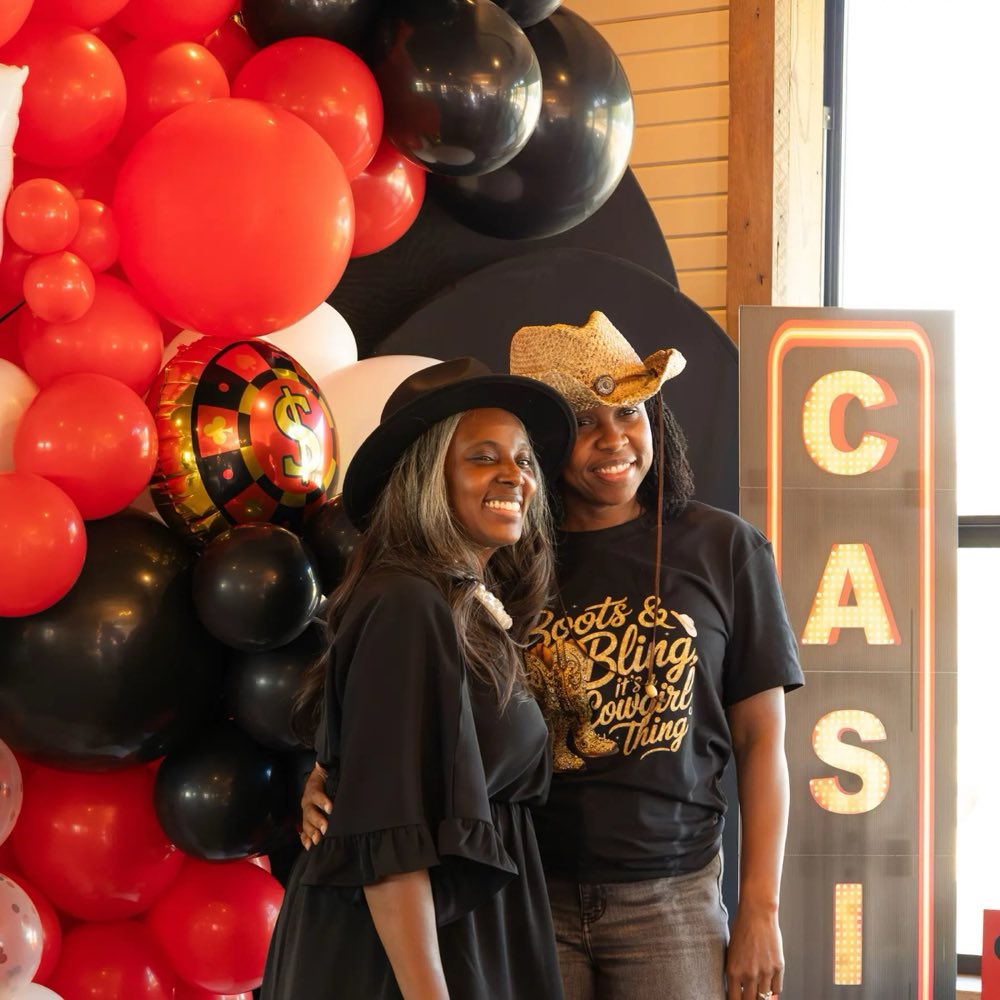 Guests with red and black balloon arch